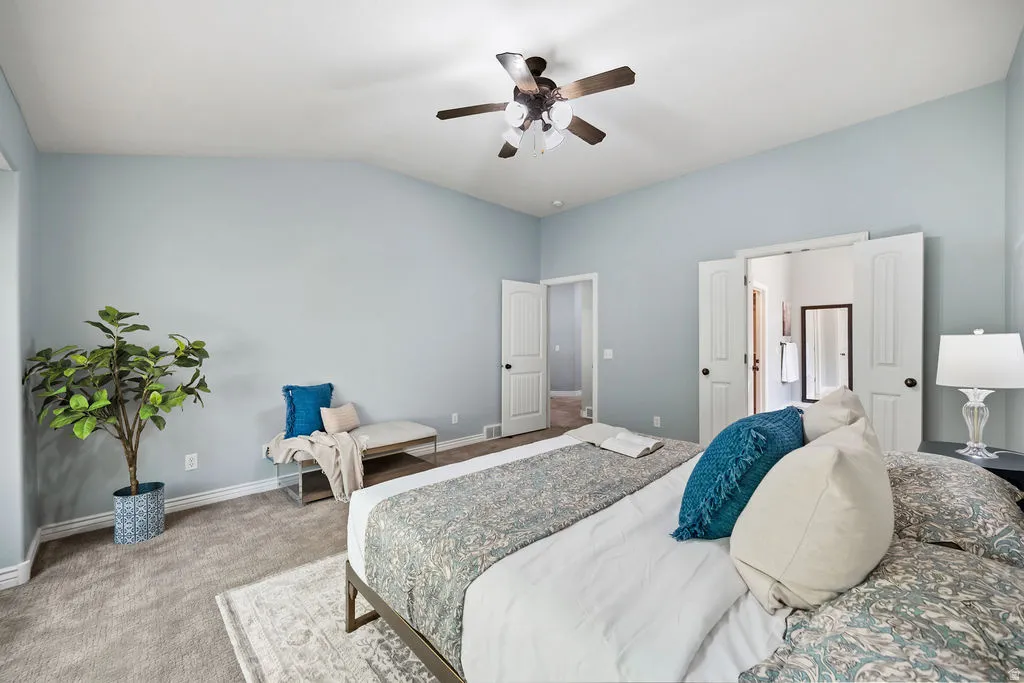 Vaulted ceiling featuring a ceiling fan with light fixture