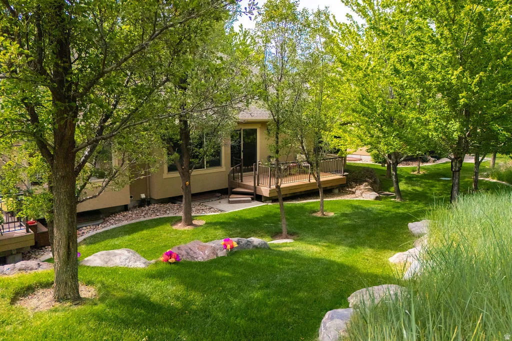 Manicured lawn with mature trees and stone accents