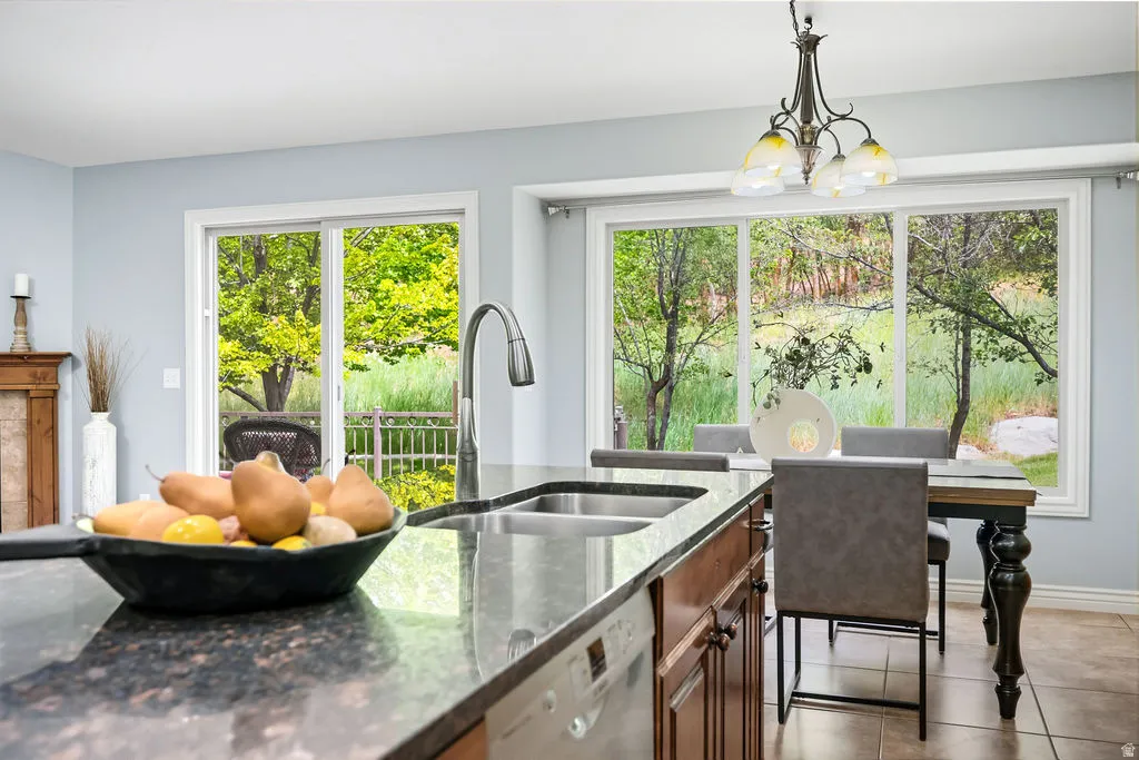 Kitchen featuring granite countertops, double basin sink with gooseneck faucet, and wood-finish cabinetry