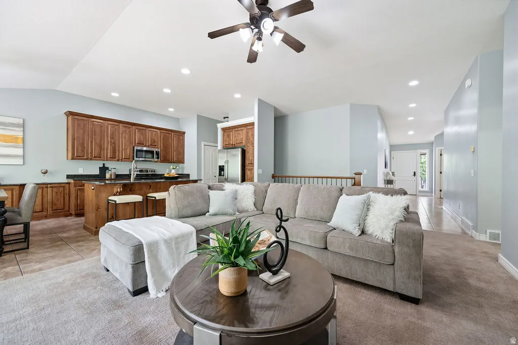 Open-concept living area featuring a vaulted ceiling and recessed lighting