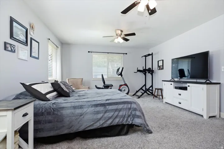 Spacious room featuring light-colored walls and soft carpet flooring