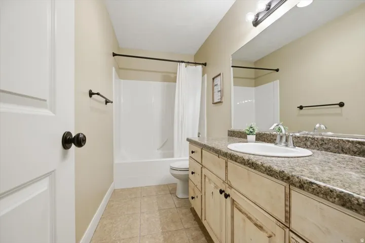 Bathroom featuring a vanity with an oval sink, an expansive mirror, and a full shower/tub combination