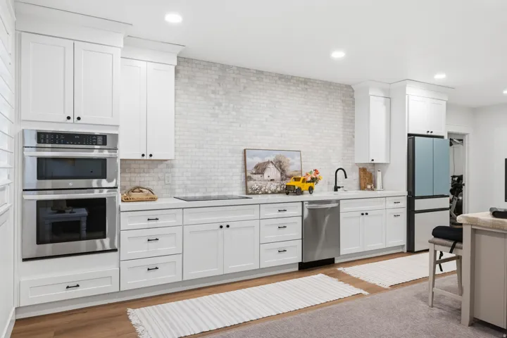 Contemporary kitchen featuring white shaker cabinetry and a subway tile backsplash
