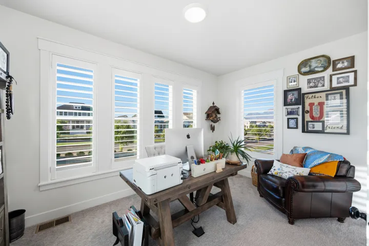 Bright room with multiple windows, plantation shutters, recessed ceiling light, and wall-to-wall carpeting