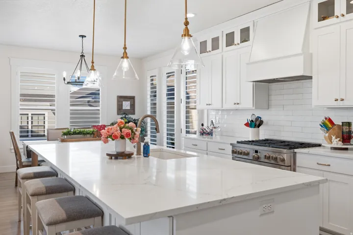 Spacious kitchen island with a light-toned countertop, integrated sink, and an elegant gooseneck faucet