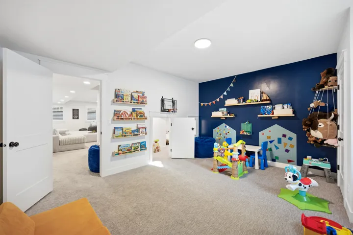 Carpeted room with a dark accent wall, recessed lighting, and built-in shelving