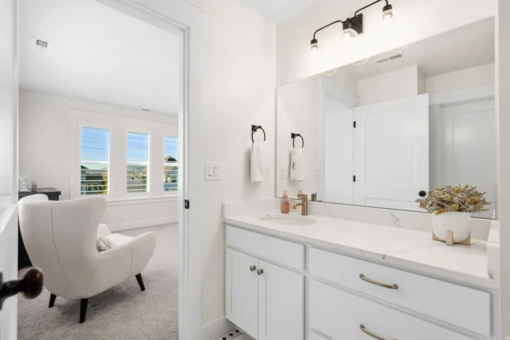 Bathroom vanity featuring a white countertop with subtle veining, undermount sink, and brushed gold-tone faucet