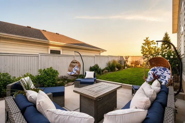 Concrete patio featuring a privacy fence and a manicured lawn