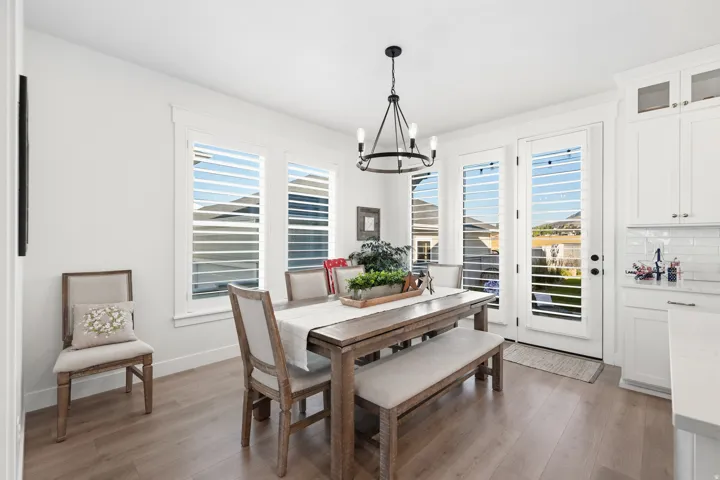 Dining area featuring wood-finish flooring and a contemporary chandelier