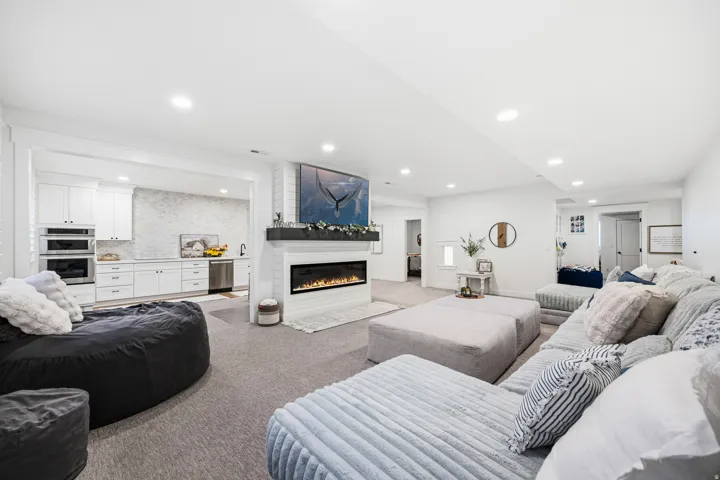 Open concept living space featuring a built-in electric fireplace with a white brick surround and dark wood mantel