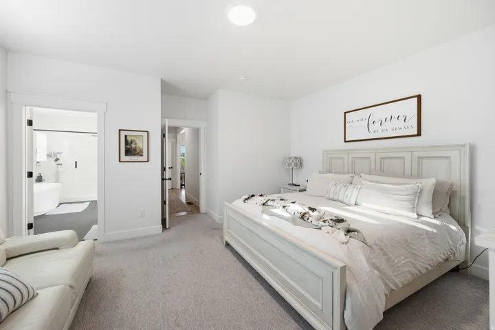 Carpeted bedroom featuring a light-colored bed frame, white walls, and a recessed ceiling light
