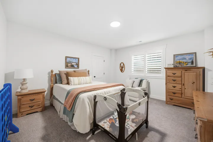 Spacious room featuring white walls, gray carpet flooring, and a round ceiling light fixture