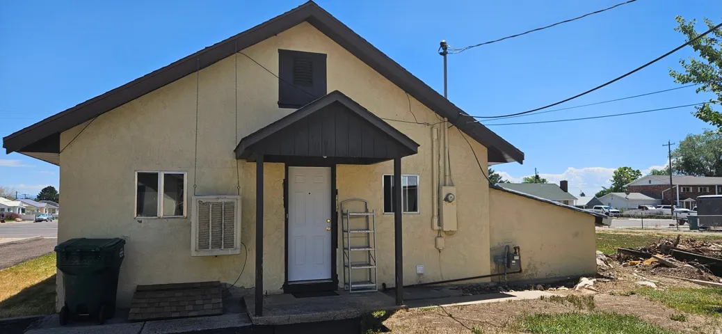 Back of main home, cream stucco exterior with a dark trim roofline