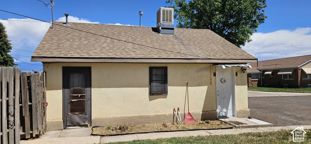 Single-story exterior with a shingle roof and stucco-style siding
