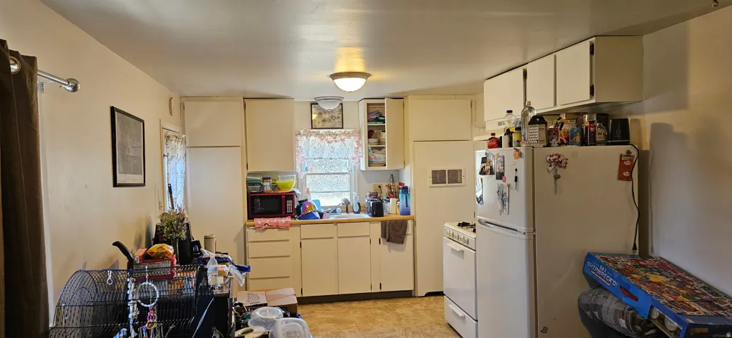 Kitchen featuring white cabinetry, light-toned countertops, and vinyl flooring