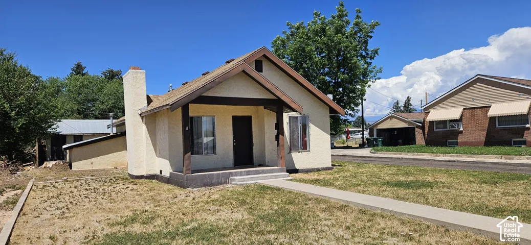 Stucco exterior with a peaked roofline and covered porch entry