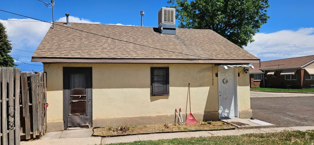 Single-story exterior with a shingle roof and stucco-style siding