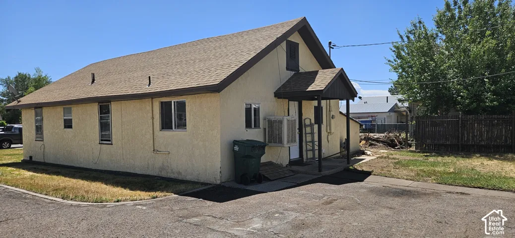 Light stucco exterior with a brown shingle roof