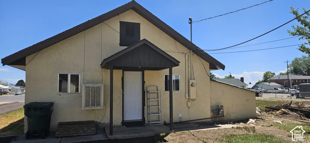 Back of main home, cream stucco exterior with a dark trim roofline