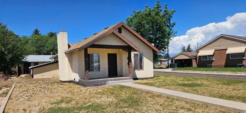 Stucco exterior with a peaked roofline and covered porch entry