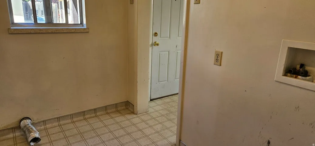 Utility area featuring a window with a stone sill, a door, and a utility hookup box