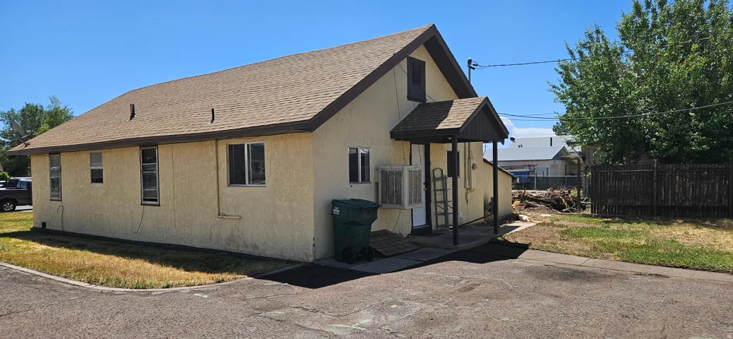 Light stucco exterior with a brown shingle roof