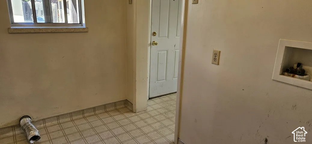Utility area featuring a window with a stone sill, a door, and a utility hookup box