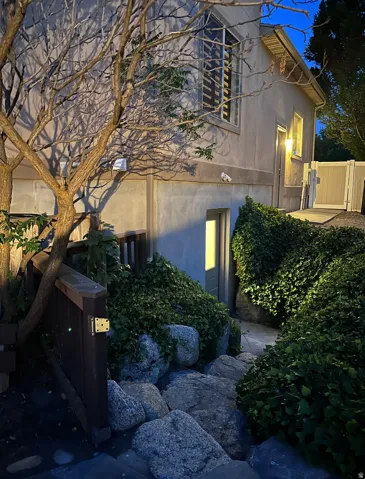 Exterior stucco finish with a large upper-level window and a ground-level entrance
