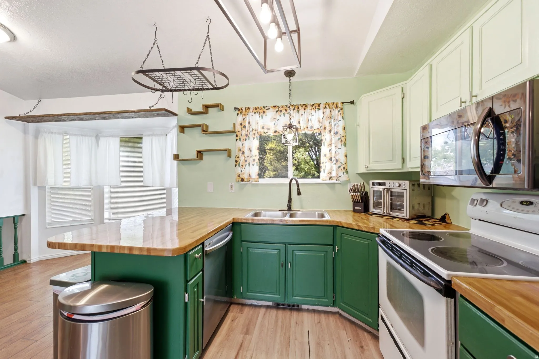 Kitchen featuring wood-finish flooring, wood countertops, and green lower cabinetry
