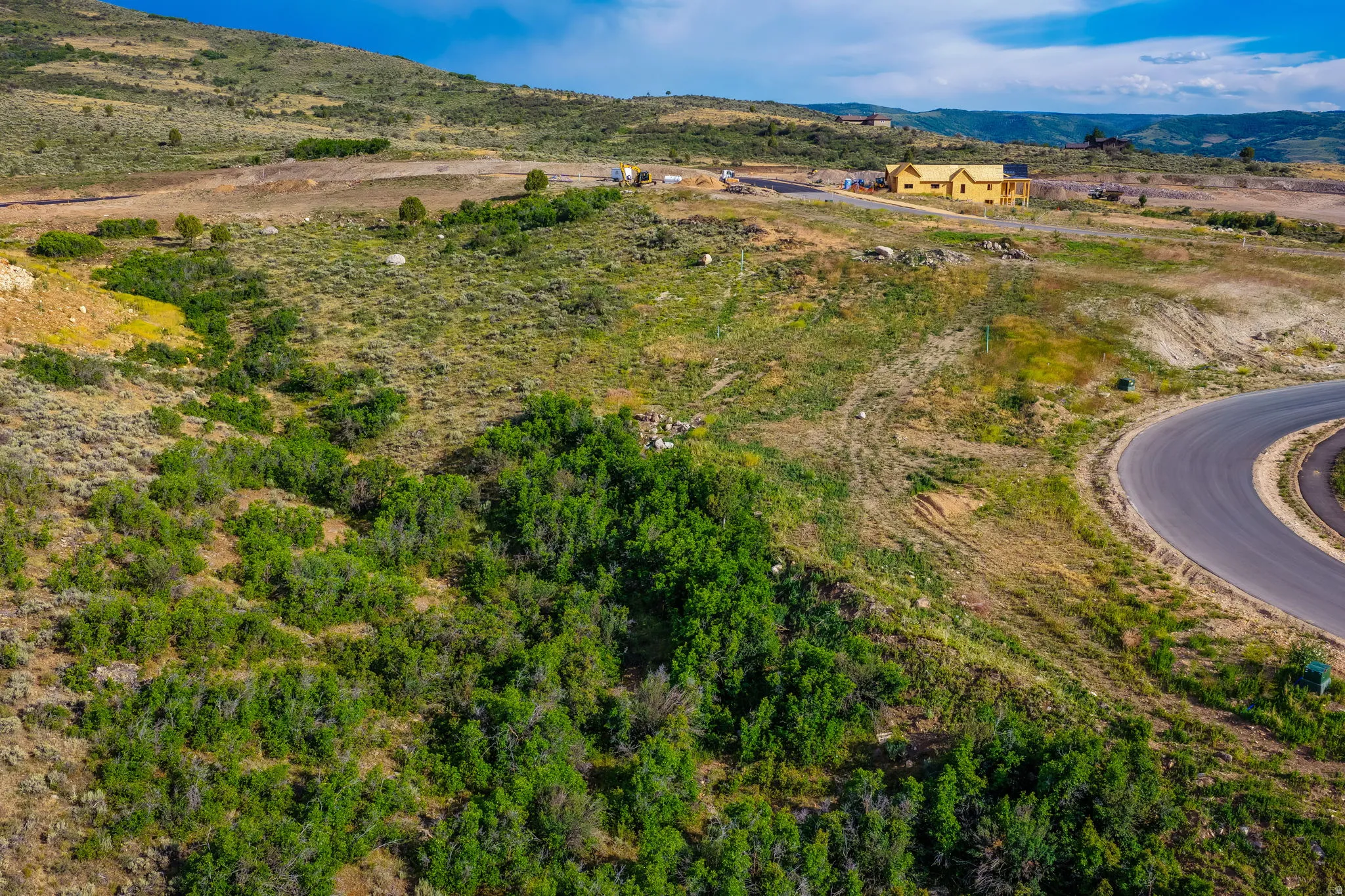 Curved paved road winding through natural, expansive terrain