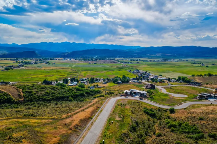 Expansive mountain-range backdrop framing a verdant valley with established communities
