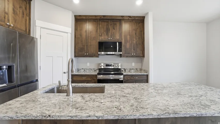 Spacious kitchen island featuring a light-toned countertop with integrated sink and chrome faucet