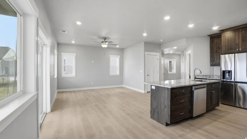 Open-concept living space featuring wood-finish flooring, recessed lighting, and a ceiling fan