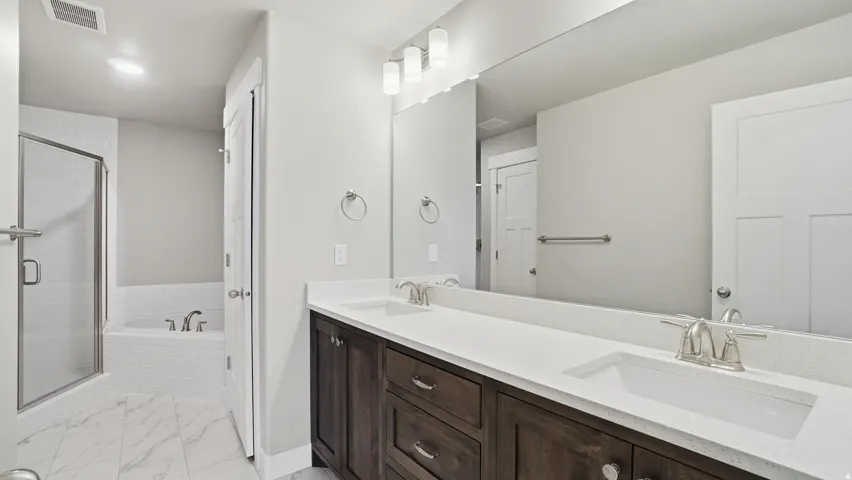 Double vanity featuring dark wood-finish cabinetry and white countertops
