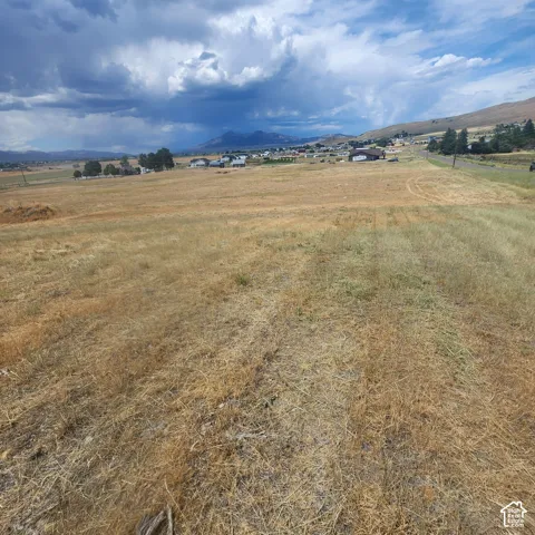Expansive land featuring a rural landscape and beautiful  mountain ranges.