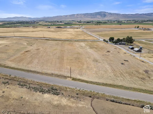 Expansive arid landscape nestled next to 2 vacant lots and a residential home.