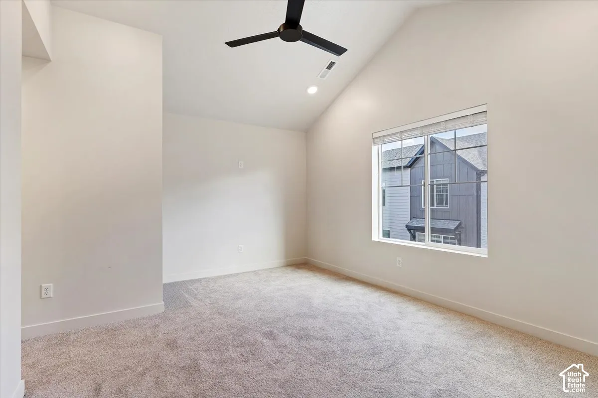 Vaulted ceiling with a black ceiling fan and recessed lighting