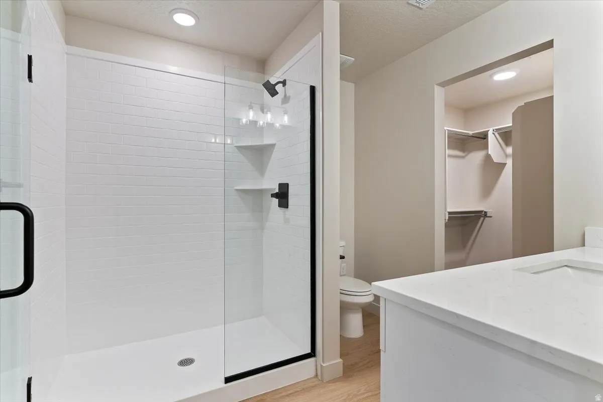 Modern bathroom featuring a glass-enclosed shower with subway tile surround, matte black fixtures, and built-in shelving