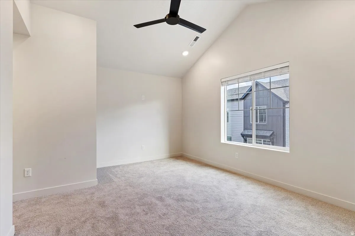 Vaulted ceiling with a black ceiling fan and recessed lighting