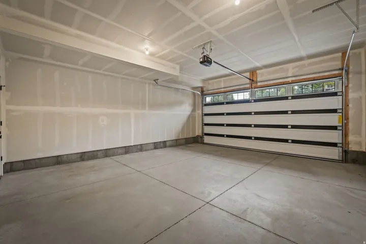 Spacious garage featuring a concrete slab floor and an overhead sectional door with top-row windows