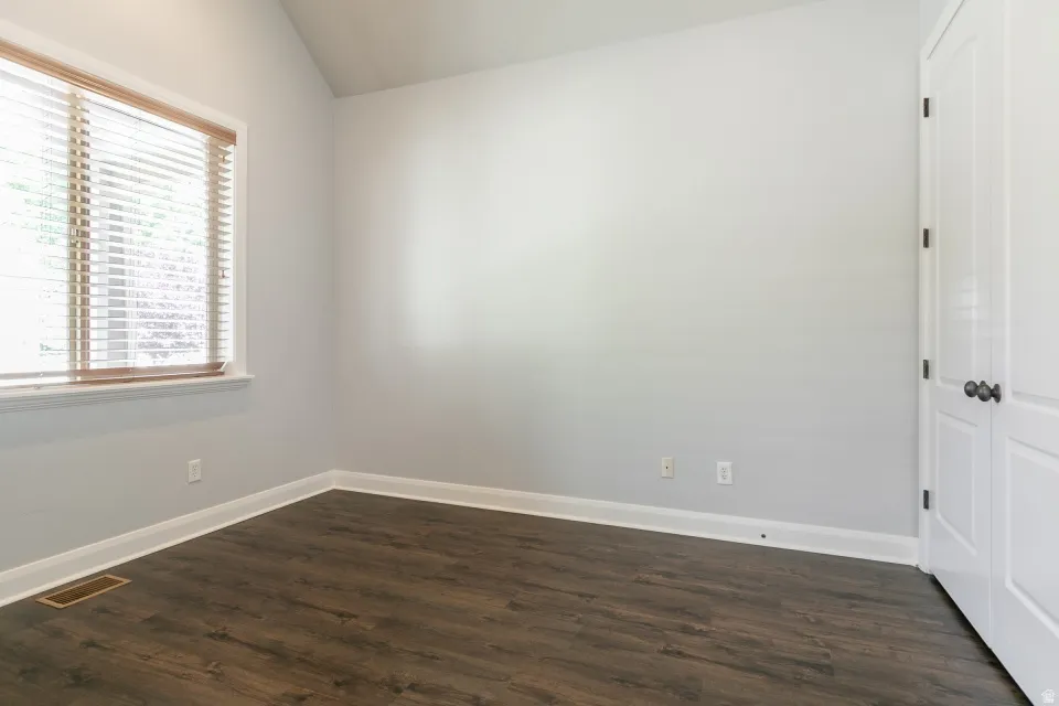 Spacious room featuring wood-finish flooring, light gray walls, and white trim