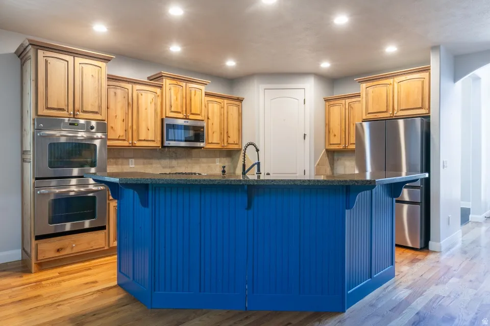 Kitchen featuring a blue beadboard island with a dark countertop and integrated sink