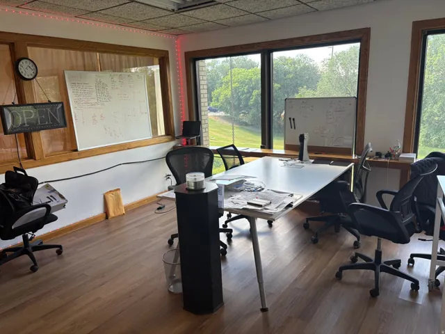 Spacious room with wood-finish flooring and multiple large windows providing ample natural light