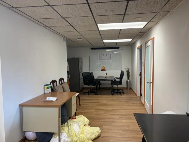 Spacious interior featuring wood-finish flooring, white walls, and a dropped ceiling with integrated lighting