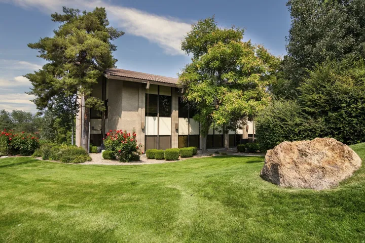 Exterior featuring a textured stucco finish, dark framed windows, and a multi-level roofline