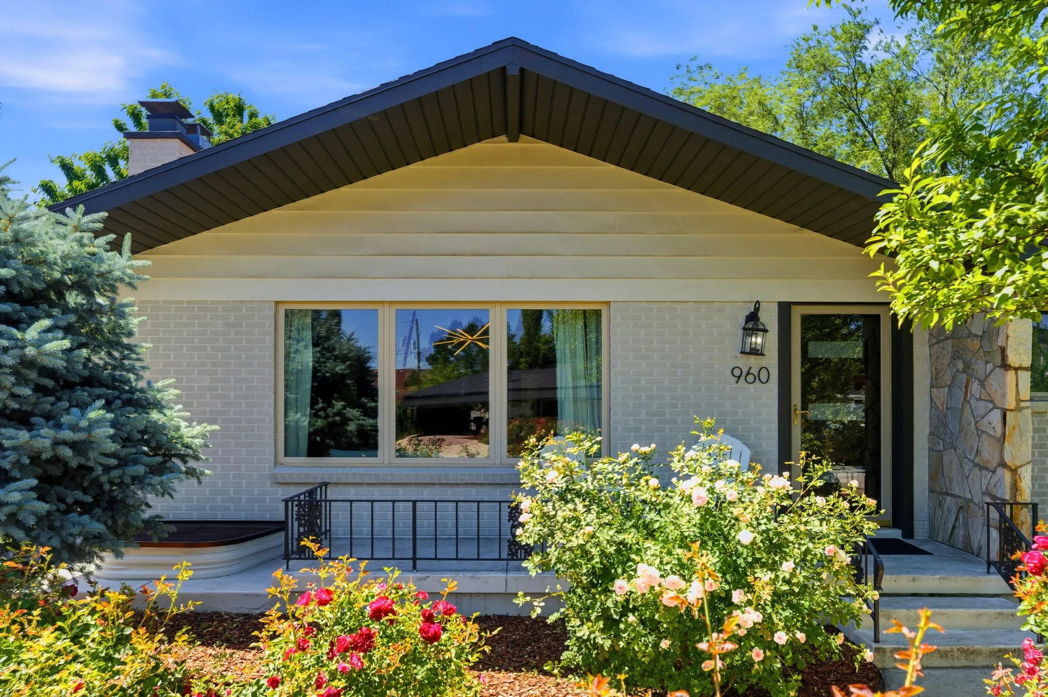 Exterior featuring light-colored brick, horizontal siding, and a dark-toned roofline