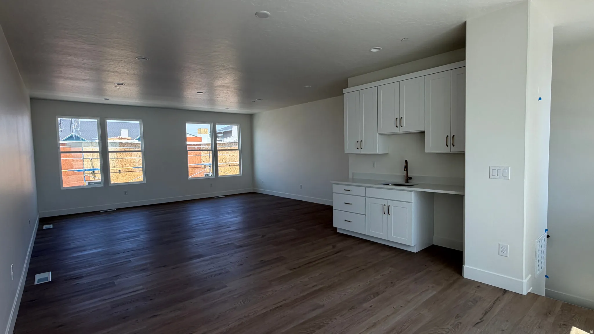Open concept room featuring wood-finish flooring, white walls, and a recessed ceiling