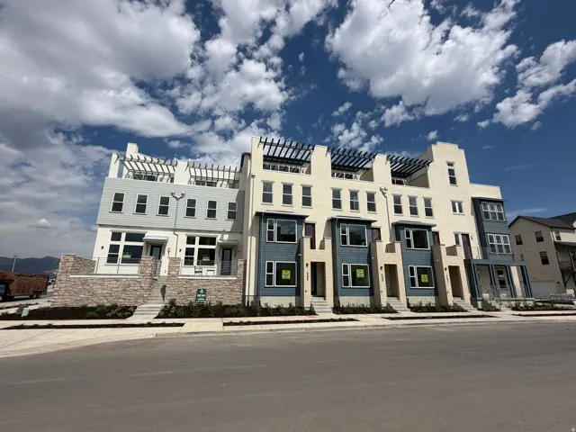 Contemporary townhome exteriors featuring varied siding, stone accents, and integrated pergolas