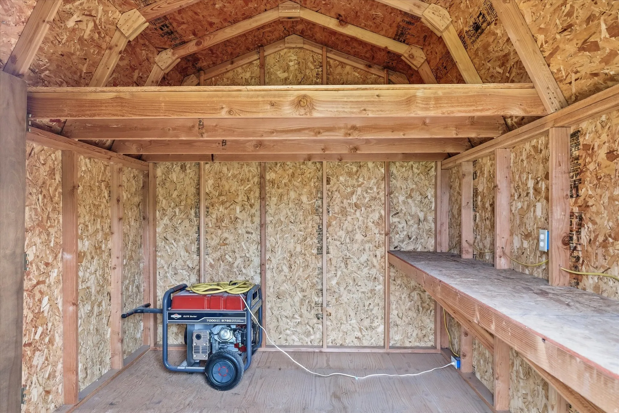 Utility shed interior featuring exposed wood framing and OSB paneling
