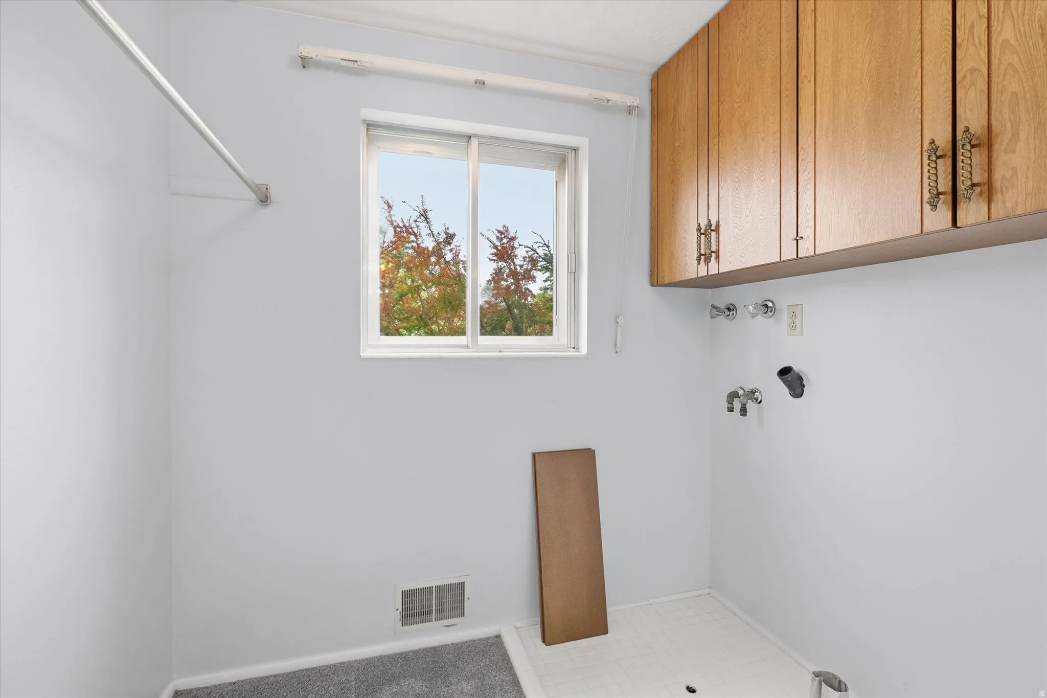 Laundry area featuring upper cabinetry, a window, and hookups for appliances